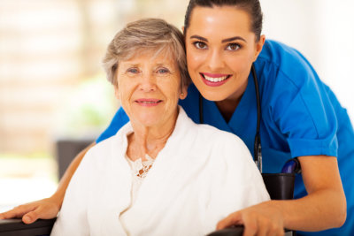 happy senior woman on wheelchair with caregiver